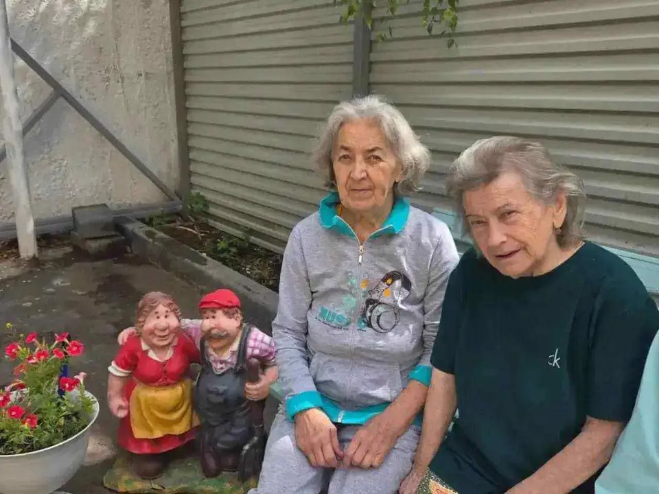 Две женщины сидят в саду пансионата