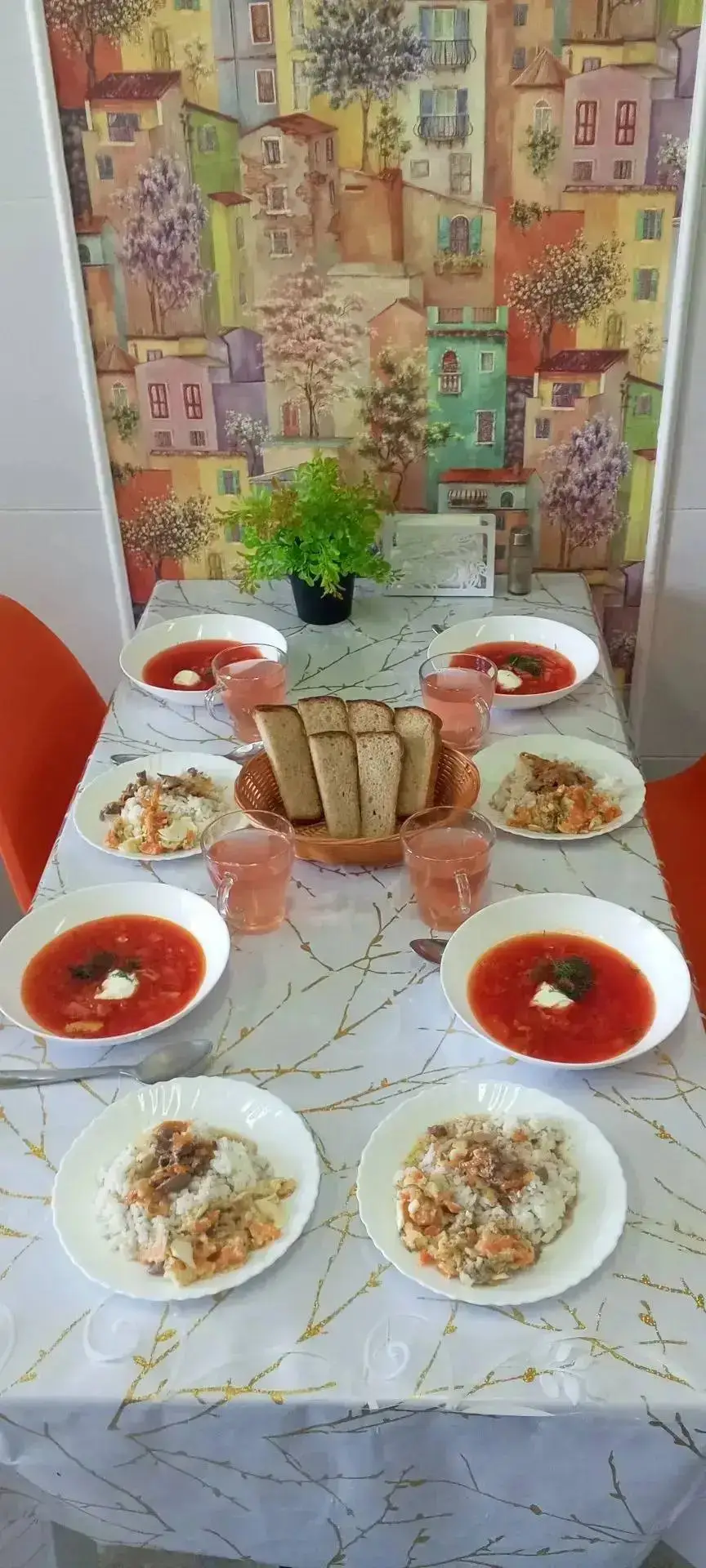 Обеденный стол с красным супом, горячими блюдами и хлебом